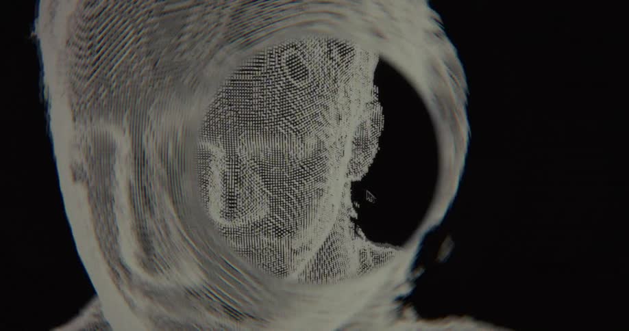 A futuristic animation shows a pixelated human head rotating and deconstructing within a digital vortex on a black background
