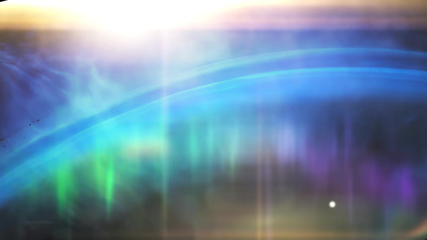 A vibrant aurora borealis shimmers with blue, green, and purple light across a planet's horizon as a bright star shines from above