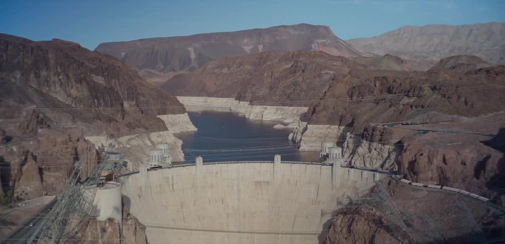 A static wide shot of the Hoover Dam and Lake Mead reveals low water levels in the Black Canyon