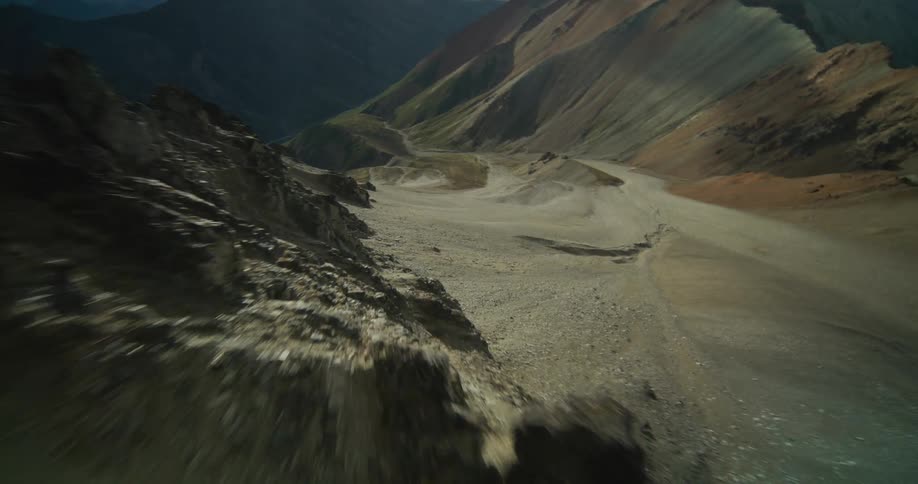 A fast-paced aerial journey soaring over the rugged and desolate ridges of a vast mountain range