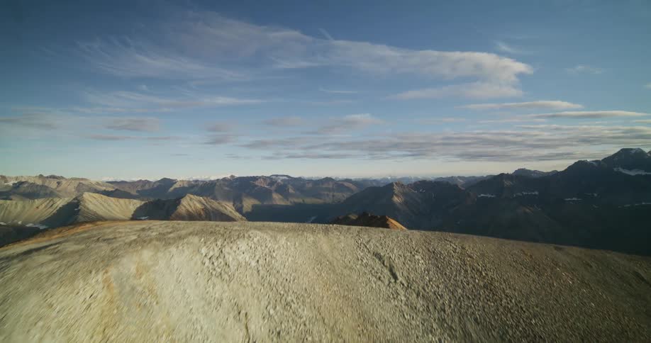 A thrilling aerial ascent up a multi-colored mountain ridge reveals a spectacular and vast remote wilderness range at sunrise