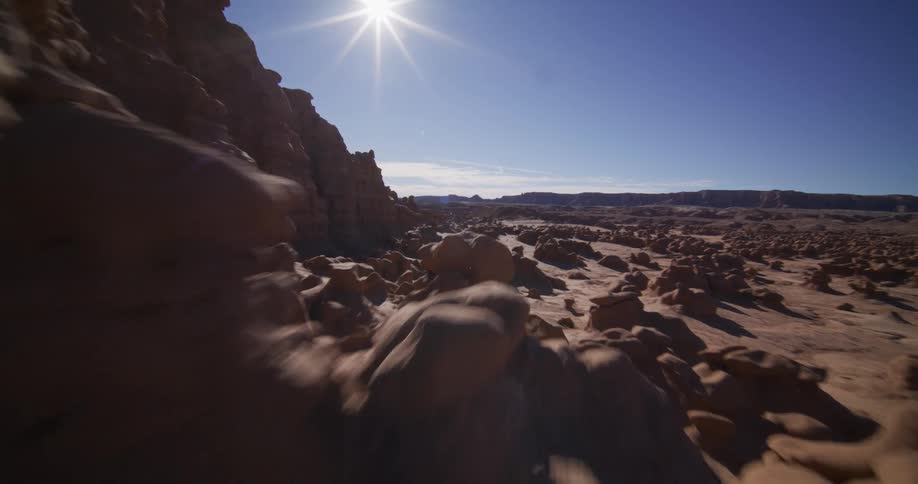 A stunning aerial shot flies low and fast through the unique hoodoo rock formations of Goblin Valley State Park in Utah