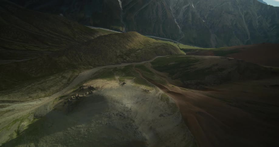 A majestic aerial view slowly reveals the epic and otherworldly terrain of a remote mountain valley at sunrise