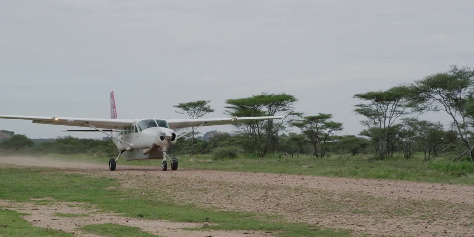 A small plane taxiing down a dirt road