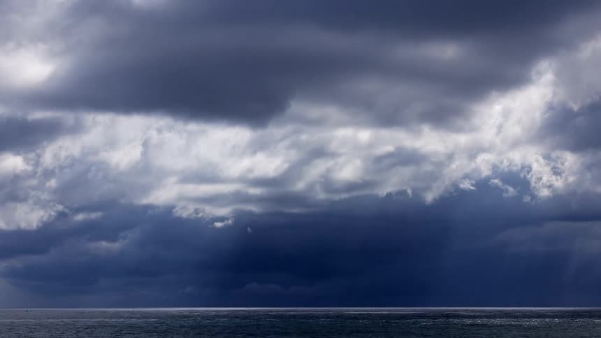 A dramatic time-lapse shows dark, ominous storm clouds gathering and rolling over the ocean