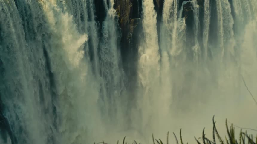 A slow tilt-down reveals the immense power and scale of the magnificent Victoria Falls in Africa