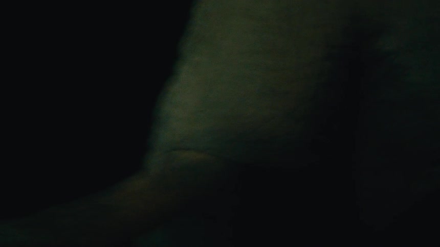 A raw, handheld close-up of an elephant's textured skin and eye, observed in the darkness of night