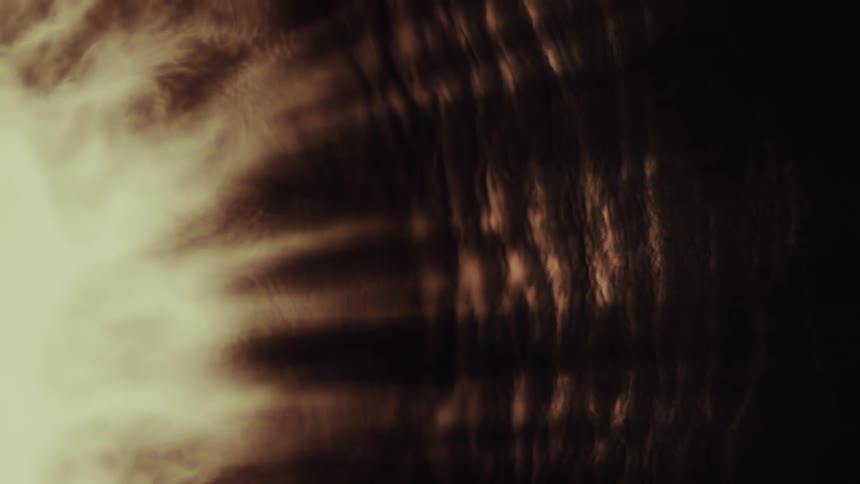 Dreamlike abstract background of dark, warm-toned ripples and shimmering textures