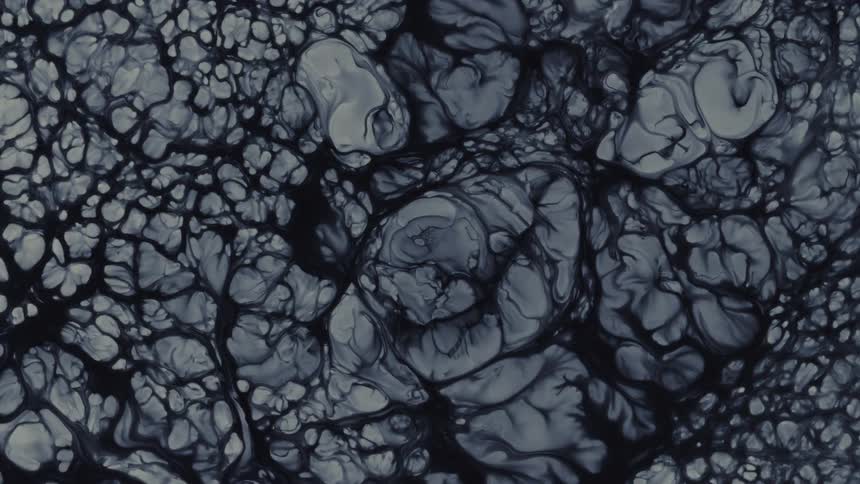 Eerie abstract background of a dark, viscous liquid forming intricate vein-like patterns in slow motion
