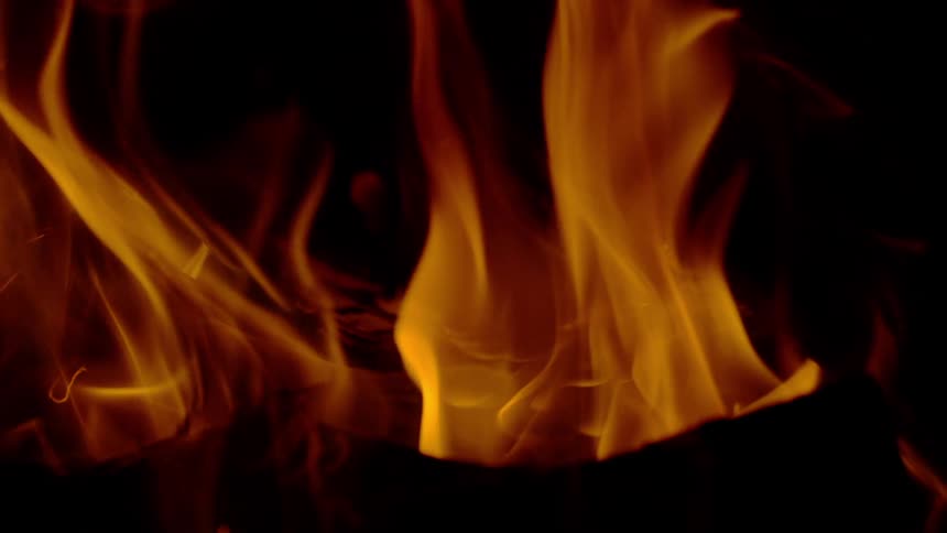 A mesmerizing close-up of vibrant orange flames dancing in slow motion against a black background