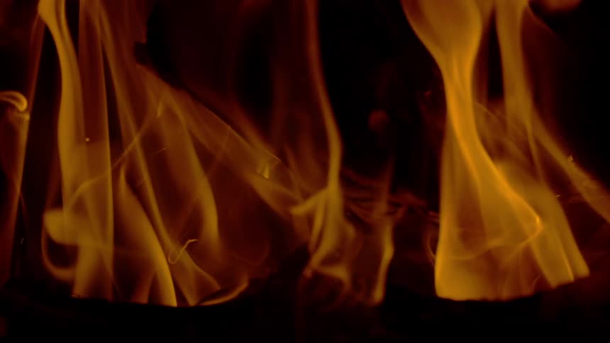 A mesmerizing slow-motion close-up of warm, dancing flames against a dark background