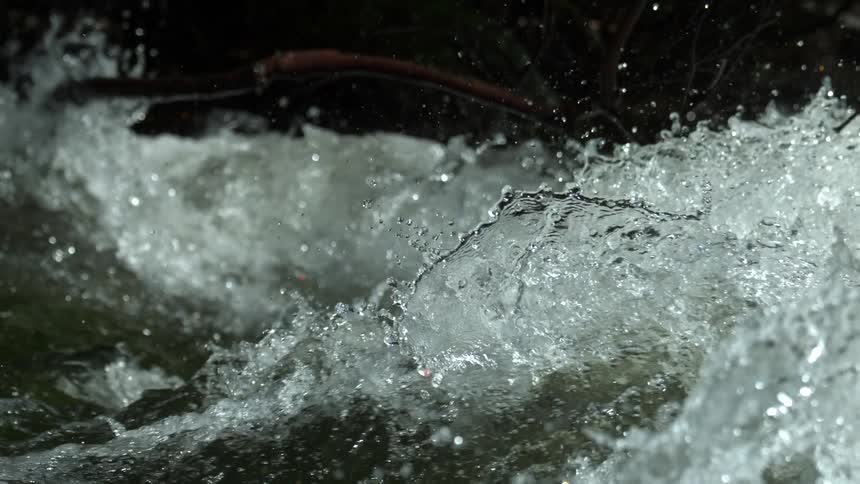 A powerful stream of water churns and splashes in a dynamic slow-motion close-up
