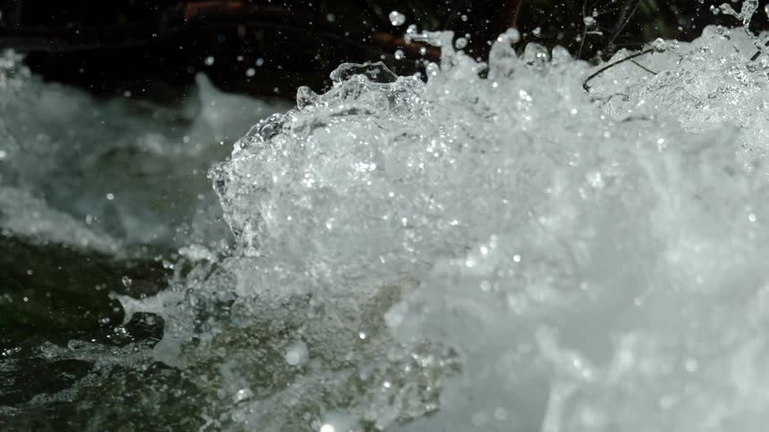 A powerful stream of water churns and splashes in a super slow-motion close-up