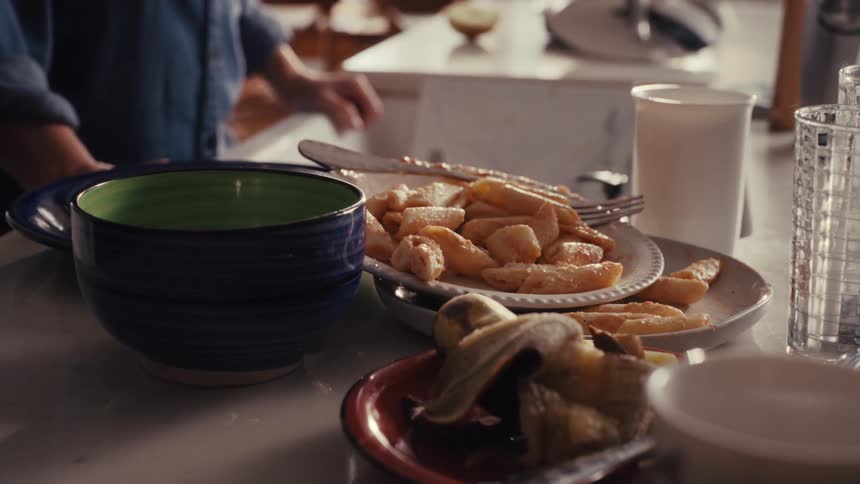 A close-up of a messy kitchen counter with dirty dishes and leftover food after a meal