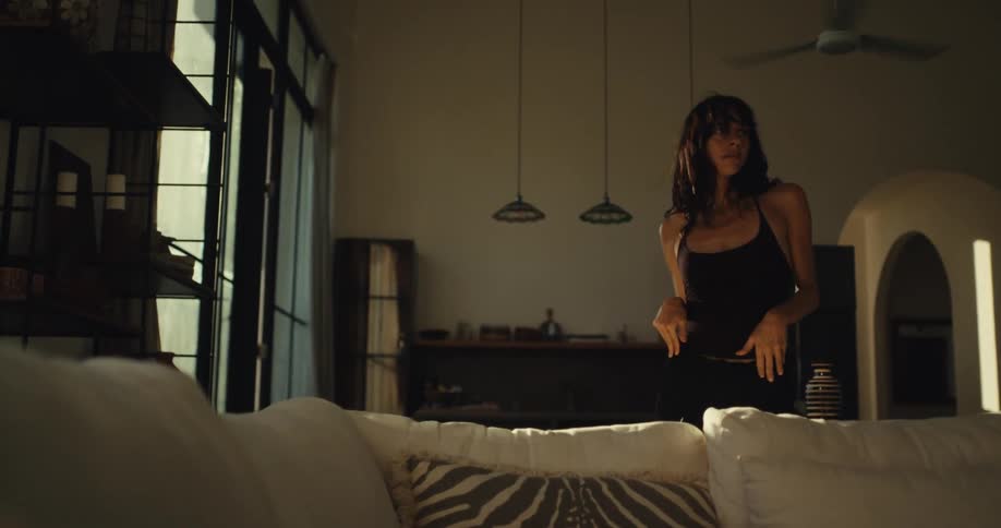 A woman dances freely and expressively in her modern, sunlit home in slow motion