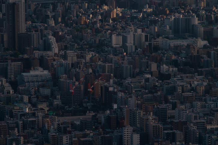 A mesmerizing time-lapse captures the sunrise slowly illuminating the dense, sprawling cityscape from a high-angle perspective