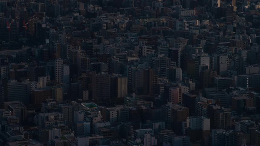 A static high-angle shot captures the vast, dense cityscape of a metropolis during the quiet moments of twilight