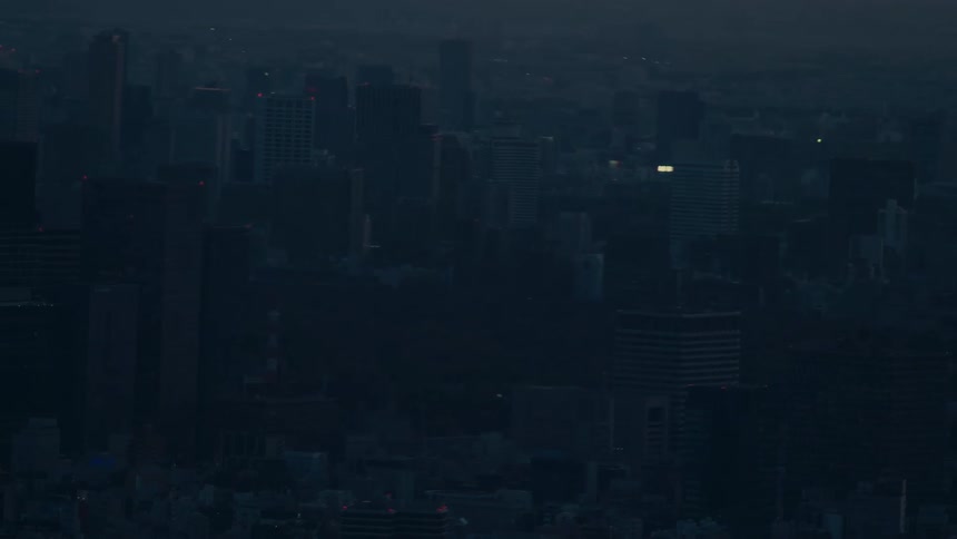 An airplane flies past the hazy silhouette of Mount Fuji at dusk before the camera zooms out to reveal the sprawling Tokyo cityscape