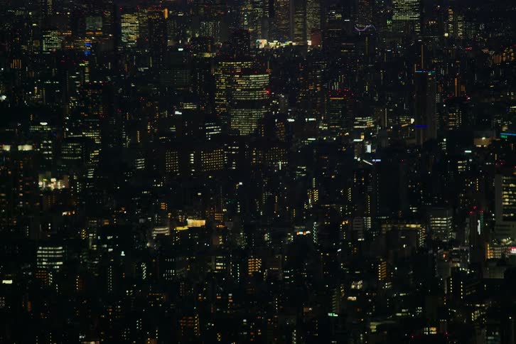 A vast and sprawling urban cityscape twinkles with countless lights at night