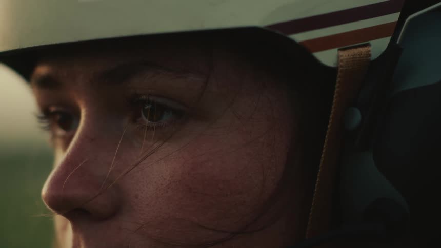 Close-up of a female pilot's determined eyes, illuminated by the golden hour sun