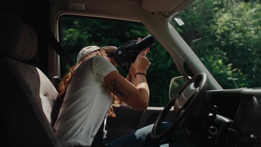 A nostalgic filmmaker captures the beauty of nature on a vintage 8mm camera from inside a camper van