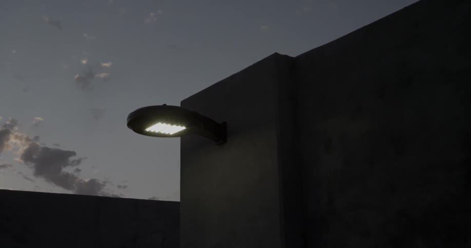 A view of a light on a building higher up and the darkening sky behind