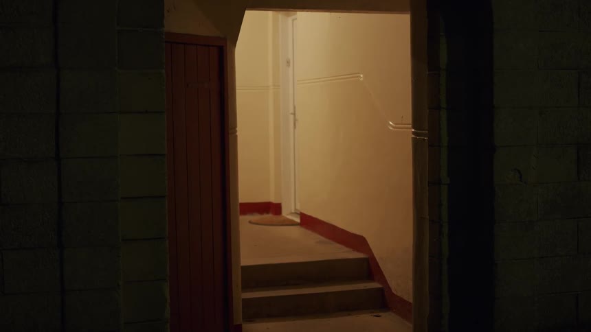 A shot of an empty, dimly lit staircase inside an old building at night