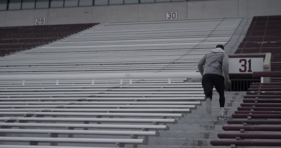 Football player runs drills up stadium bleachers