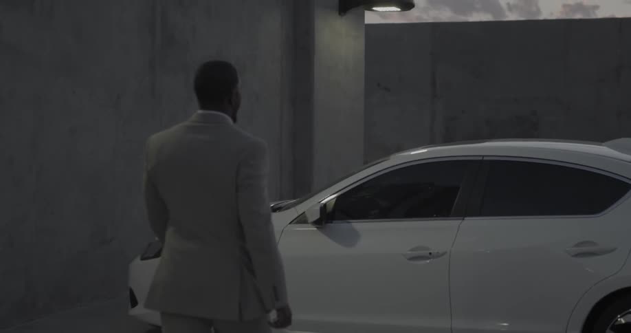 Man walks to car and opens door and gets into car