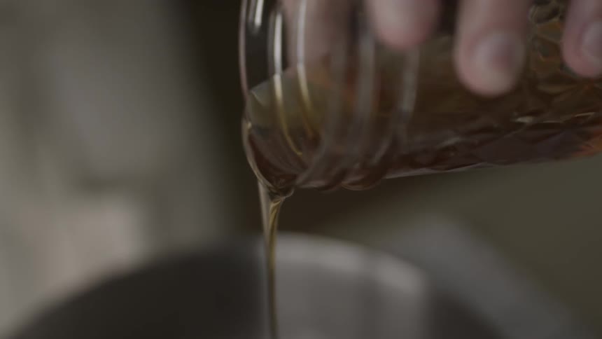 A person is pouring honey out of a jar