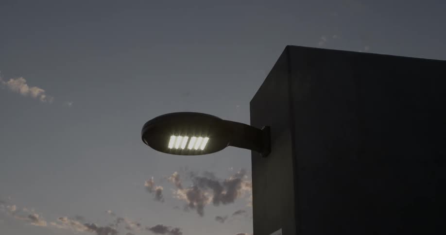 A light glows on the side of a structure at sunset
