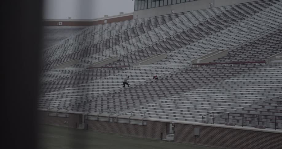 A man runs up some bleachers