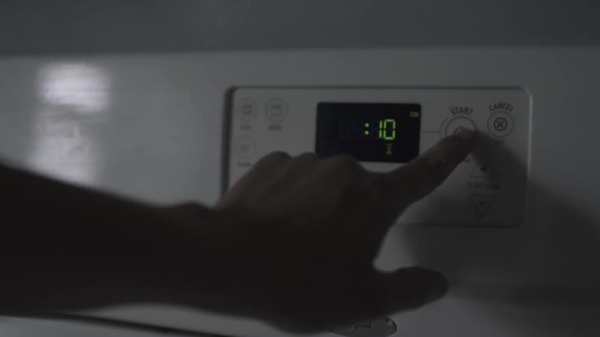 A person presses buttons on the oven