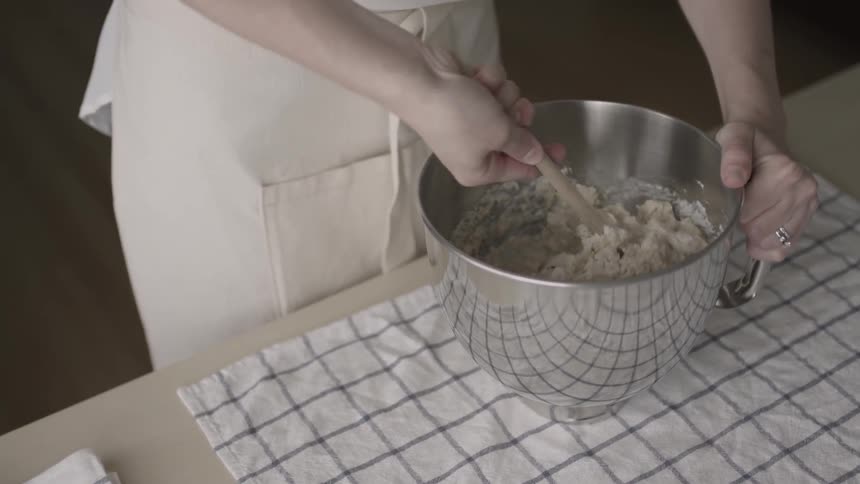 A woman is mixing batter in a bowl