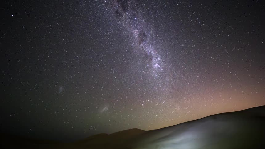 A stunning timelapse captures the Milky Way galaxy and its billions of stars moving across the night sky above a vast desert landscape