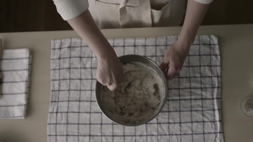 A woman stirs ingredients in a bowl