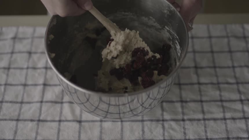 Someone mixes chocolate into dough