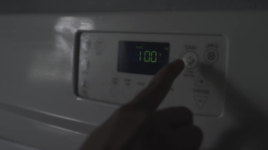A person pushes a start button on an appliance