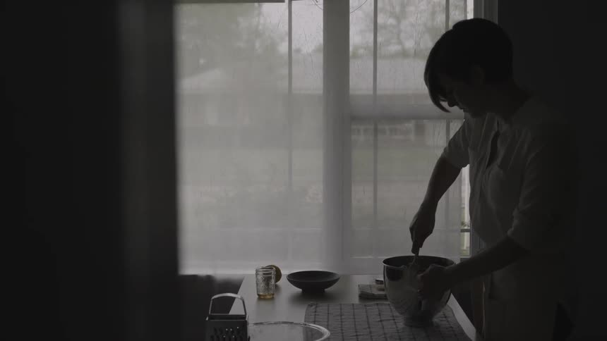 A woman is mixing something in a bowl