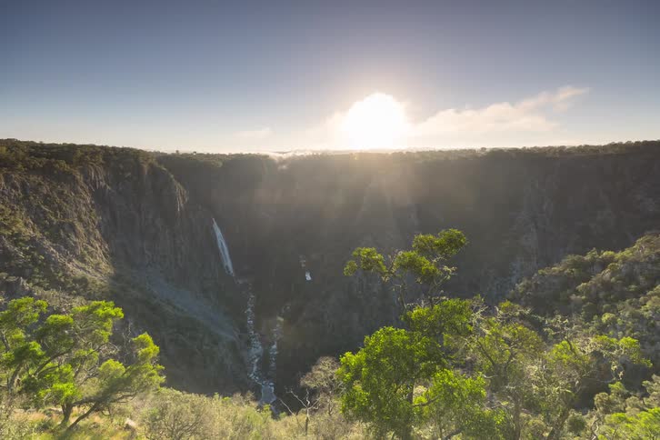 A misty sunrise time-lapse reveals a majestic waterfall and river in a deep gorge as the fog clears