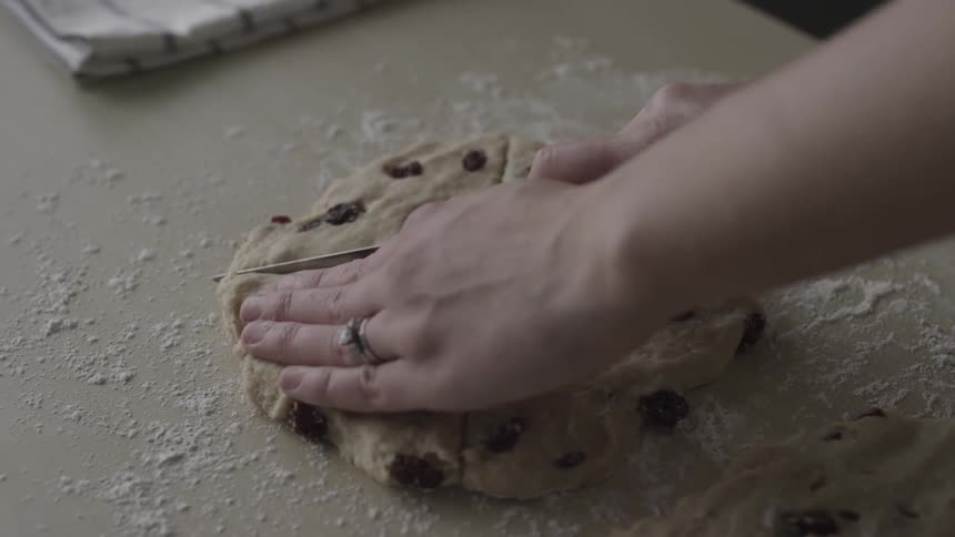 Person cuts raw cookie dough into wedges