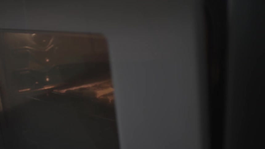 A person putting in cookies into the oven to bake