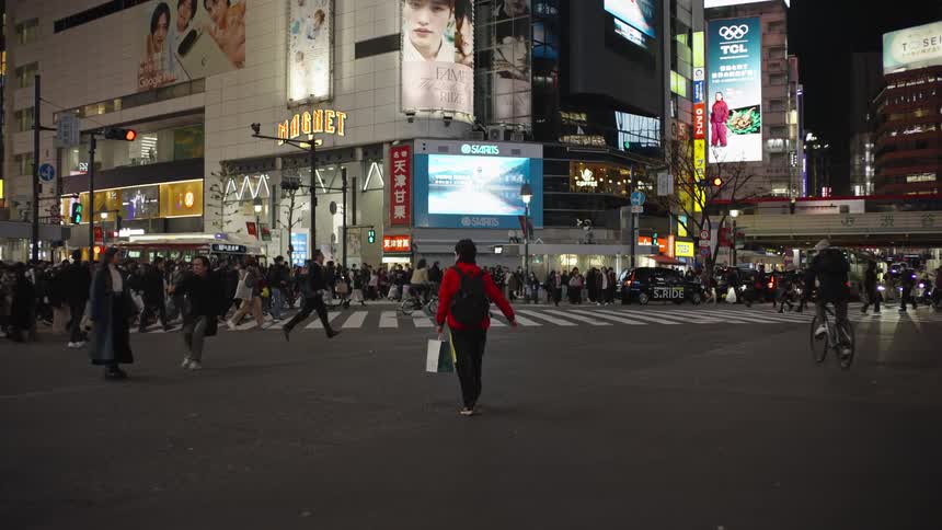 A mesmerizing slow-motion shot captures the nightly pedestrian scramble at the iconic Shibuya Crossing in Tokyo, Japan