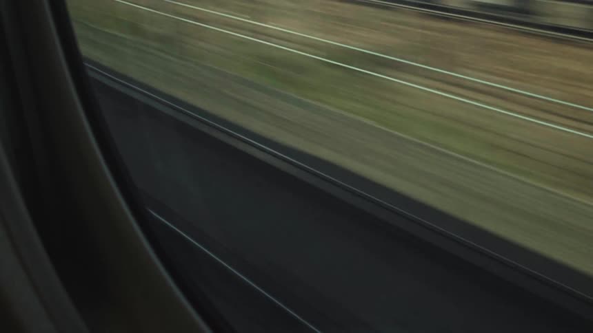 Abstract motion blur of train tracks and the ground as seen from a fast-moving train window
