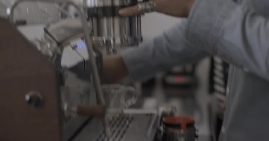 A person making a hot cup of coffee
