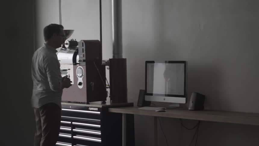 A man stands next to a computer and equipment