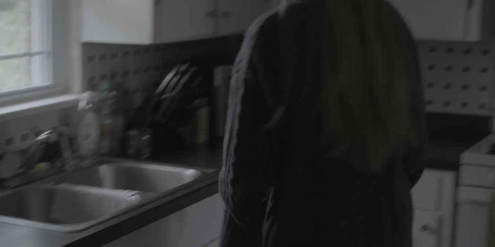 A woman closes the lid of a coffee maker