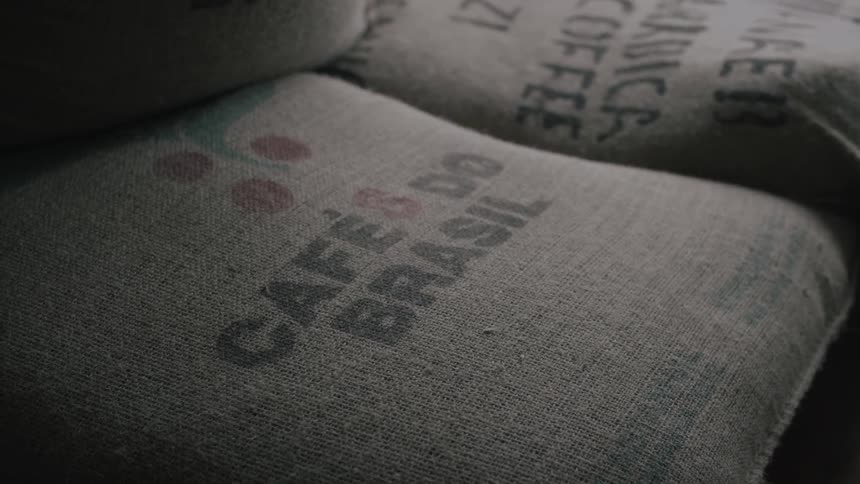 Bags of coffee beans sit in a stack