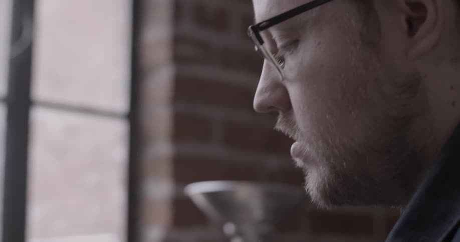 A man is putting labels on coffee bags