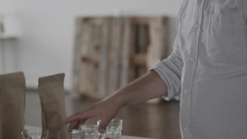 A man smells glasses of coffee beans